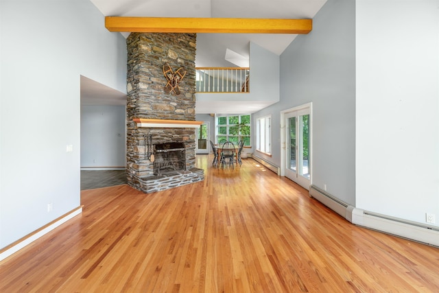 650 Perry Lea Rd, Waterbury, VT 05676 - living room with high vaulted ceiling, wood finished floors, a fireplace, beamed ceiling, and a baseboard heating unit