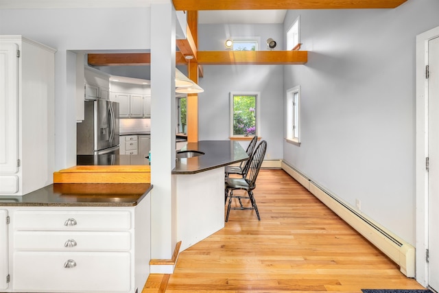 650 Perry Lea Rd, Waterbury, VT 05676 - kitchen with stainless steel refrigerator with ice dispenser, dark countertops, baseboard heating, and light wood-style flooring