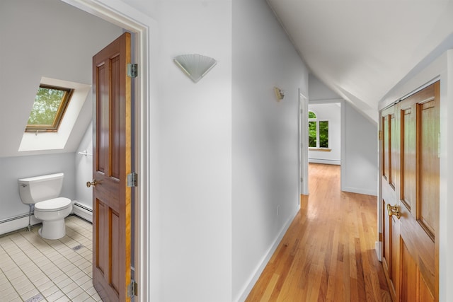 650 Perry Lea Rd, Waterbury, VT 05676 - hall featuring vaulted ceiling, baseboard heating, a skylight, a baseboard heating unit, and light wood-style floors