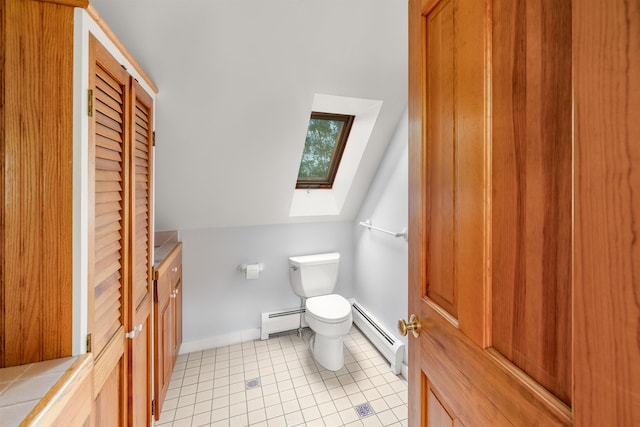 650 Perry Lea Rd, Waterbury, VT 05676 - half bathroom featuring a skylight, a baseboard heating unit, tile patterned flooring, vanity, and lofted ceiling