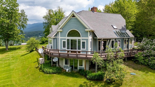 650 Perry Lea Rd, Waterbury, VT 05676 - back of property featuring a yard, a chimney, and a deck with mountain view