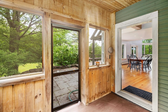 650 Perry Lea Rd, Waterbury, VT 05676 - doorway to outside with wood walls, baseboard heating, and wood finished floors