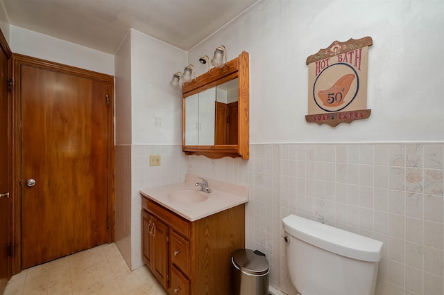 10 Eastern Ave, Rochester, NH 03867 - half bath with vanity, tile walls, and a wainscoted wall