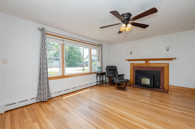 10 Eastern Ave, Rochester, NH 03867 - living area with wood finished floors, a brick fireplace, baseboard heating, and a ceiling fan