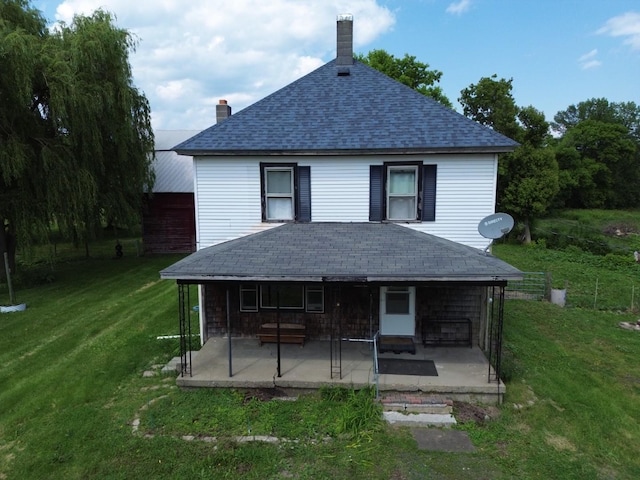 180 E Shore S, Grand Isle, VT 05458 - rear view of house featuring a shingled roof, a patio, a yard, and a chimney
