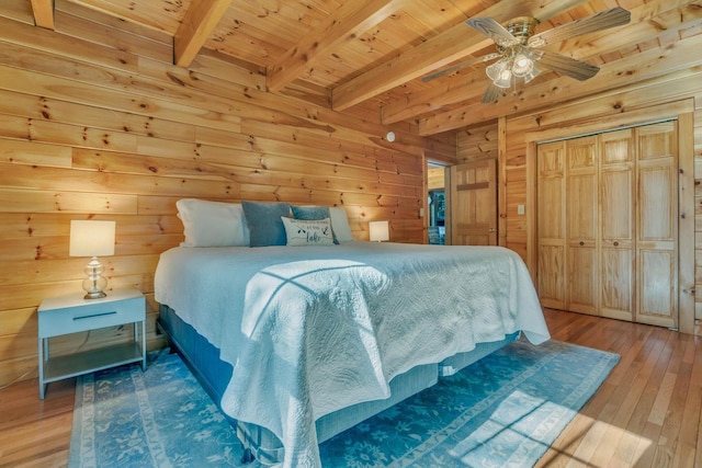 67 Cardinal Ln, Smithfield, ME 04978 - bedroom featuring a wooden ceiling with exposed beams, light wood-style flooring, wooden walls, a closet, and a ceiling fan