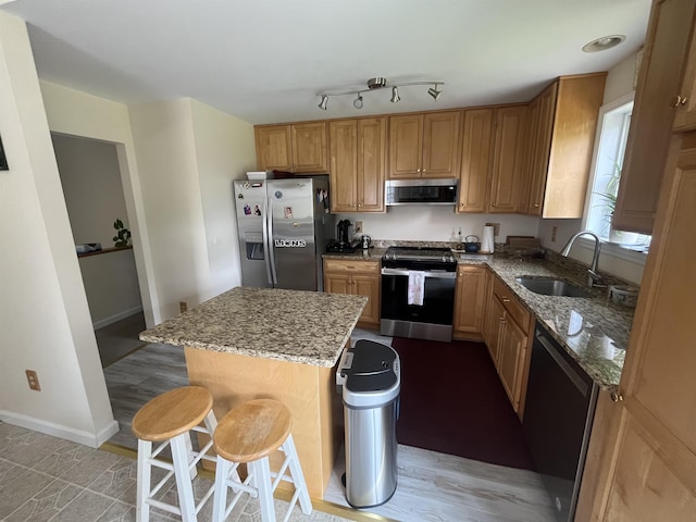 13 Bartlett St, Allenstown, NH 03275 - kitchen with stainless steel appliances, light stone counters, a center island, a kitchen bar, and light wood-type flooring