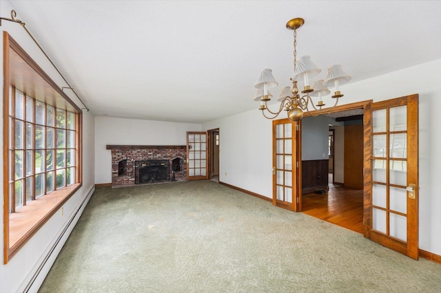 240 Middle Winchendon Rd, Rindge, NH 03461 - unfurnished living room featuring a baseboard radiator, carpet flooring, french doors, a brick fireplace, and a chandelier