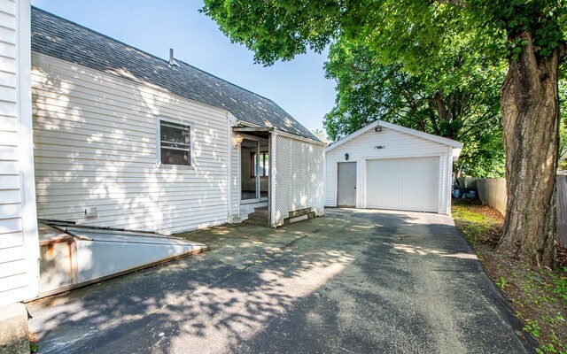 4 Walnut St, Exeter, NH 03833 - view of side of home with a detached garage, asphalt driveway, an outdoor structure, and a shingled roof