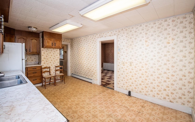 4 Walnut St, Exeter, NH 03833 - kitchen featuring baseboard heating, freestanding refrigerator, light countertops, light floors, and brown cabinets