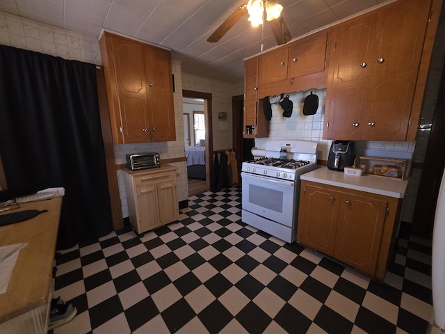 793 S Beech St, Manchester, NH 03104 - kitchen with white gas range, light flooring, light countertops, and ceiling fan