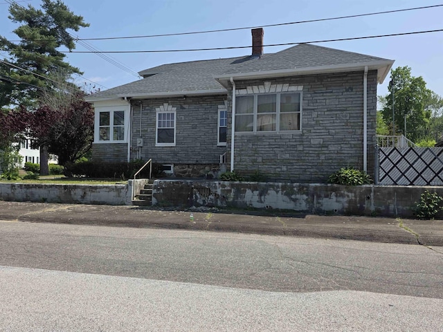 793 S Beech St, Manchester, NH 03104 - view of front of house with stone siding, a chimney, and roof with shingles