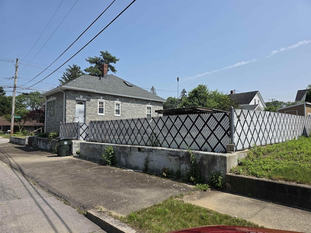 793 S Beech St, Manchester, NH 03104 - view of side of home featuring stone siding and a chimney
