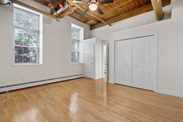 156 Front St Unit 103, Exeter, NH 03833 - unfurnished bedroom featuring a wood ceiling with exposed beams, baseboard heating, light wood-style floors, a closet, and a ceiling fan