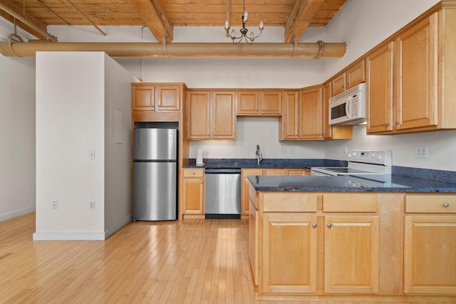 156 Front St Unit 103, Exeter, NH 03833 - kitchen featuring stainless steel appliances, a peninsula, light wood-style flooring, a wooden ceiling with exposed beams, and dark stone countertops