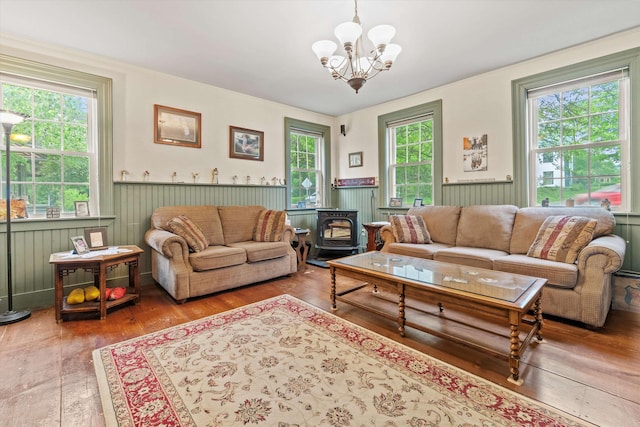235 Dartmouth College Hwy, Haverhill, NH 03765 - living room with a wood stove, a chandelier, wainscoting, and hardwood / wood-style floors