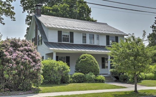 45 School St, Keene, NH 03431 - view of front of house featuring a standing seam roof, a metal roof, covered porch, a front lawn, and a chimney