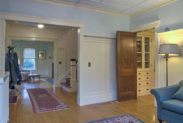 45 School St, Keene, NH 03431 - living area featuring a decorative wall, wood-type flooring, stairway, wainscoting, and ornamental molding