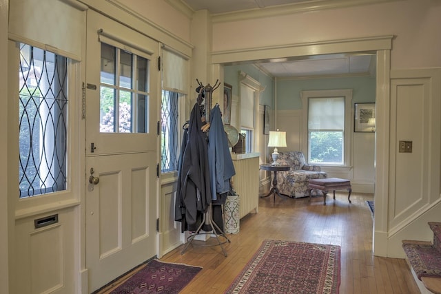45 School St, Keene, NH 03431 - entrance foyer with ornamental molding, light wood finished floors, a decorative wall, and a wainscoted wall