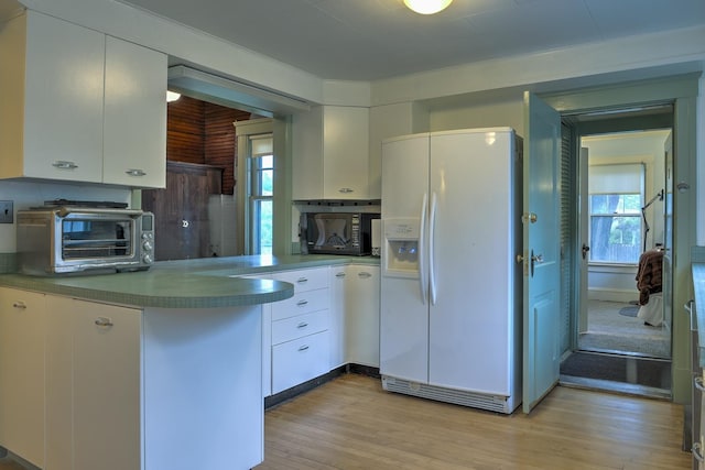 45 School St, Keene, NH 03431 - kitchen featuring white refrigerator with ice dispenser, black microwave, light wood finished floors, white cabinets, and healthy amount of natural light