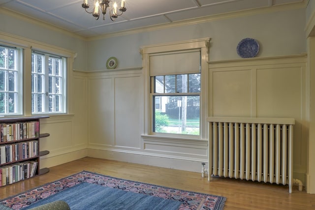 45 School St, Keene, NH 03431 - unfurnished room featuring a decorative wall, radiator heating unit, wood finished floors, plenty of natural light, and a chandelier