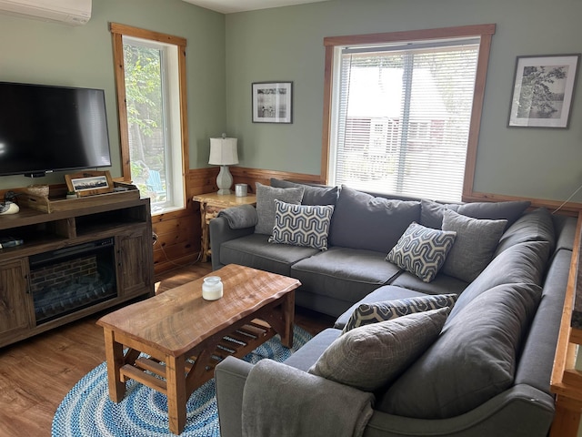 26 Island Dr, Madison, NH 03849 - living room featuring a wall mounted air conditioner, wood finished floors, and wainscoting