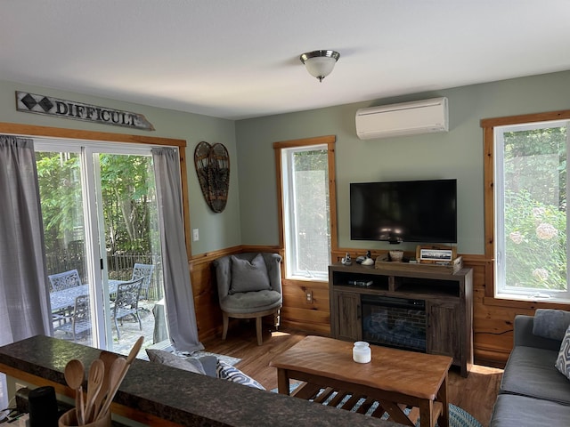 26 Island Dr, Madison, NH 03849 - living area with a wall mounted air conditioner, a wainscoted wall, plenty of natural light, wood walls, and wood finished floors