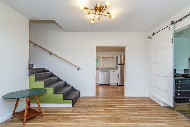 53 Broad Cove Dr, Concord, NH 03303 - stairway with a barn door, wood finished floors, and a chandelier