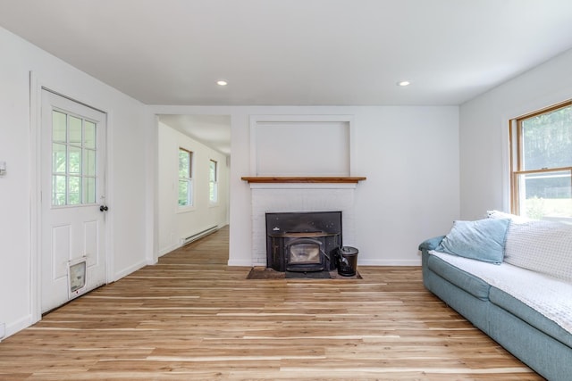 53 Broad Cove Dr, Concord, NH 03303 - living area featuring a baseboard heating unit, light wood-style floors, recessed lighting, and a wood stove