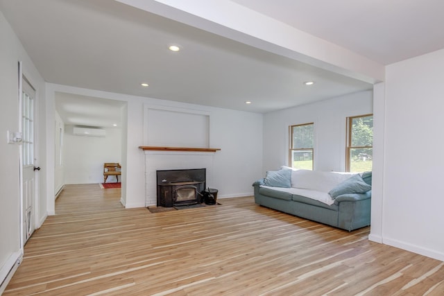 53 Broad Cove Dr, Concord, NH 03303 - living room featuring a wall mounted air conditioner, light wood finished floors, a wood stove, and recessed lighting