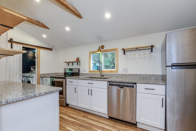 53 Broad Cove Dr, Concord, NH 03303 - kitchen with appliances with stainless steel finishes, washer and clothes dryer, light wood-style floors, white cabinetry, and light stone countertops
