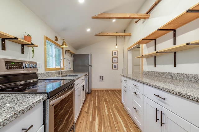 53 Broad Cove Dr, Concord, NH 03303 - kitchen with open shelves, stainless steel appliances, lofted ceiling, white cabinetry, and light wood-style flooring