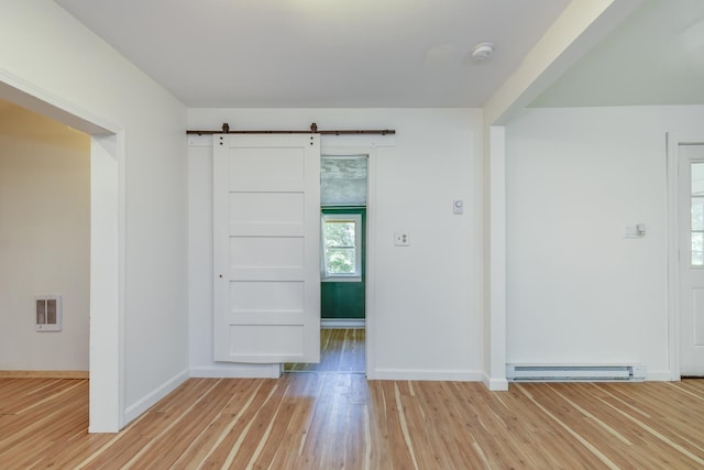 53 Broad Cove Dr, Concord, NH 03303 - spare room with light wood-style floors, a barn door, a baseboard heating unit, a smoke detector, and heating unit