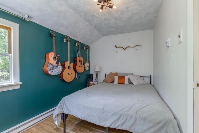 53 Broad Cove Dr, Concord, NH 03303 - bedroom featuring wood finished floors, lofted ceiling, a textured ceiling, and a baseboard heating unit
