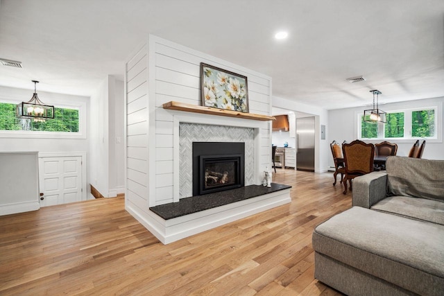 10 Lawrence Ln, Hollis, NH 03049 - living area featuring light wood-type flooring, plenty of natural light, a chandelier, a fireplace, and recessed lighting