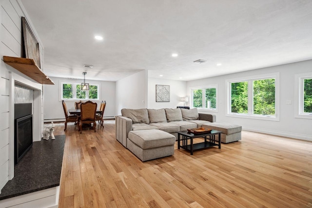 10 Lawrence Ln, Hollis, NH 03049 - living area with light wood-style flooring, plenty of natural light, a glass covered fireplace, recessed lighting, and baseboard heating
