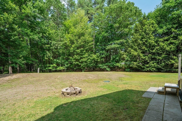 10 Lawrence Ln, Hollis, NH 03049 - view of grassy yard featuring a fire pit and a view of trees