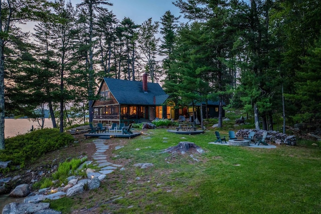 310 Bear Is, Meredith, NH 03253 - rear view of house featuring a fire pit, a sunroom, a yard, a chimney, and a patio area