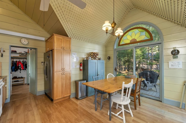310 Bear Is, Meredith, NH 03253 - dining area with wood walls, light wood-style floors, a chandelier, ceiling fan, and high vaulted ceiling