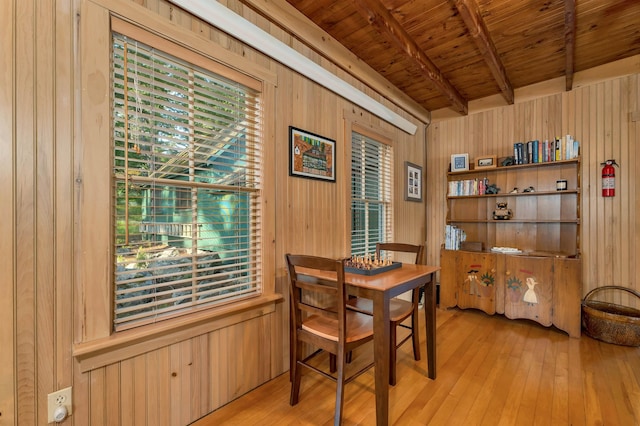 310 Bear Is, Meredith, NH 03253 - dining space with wood walls, a wood ceiling with exposed beams, and light wood-style flooring