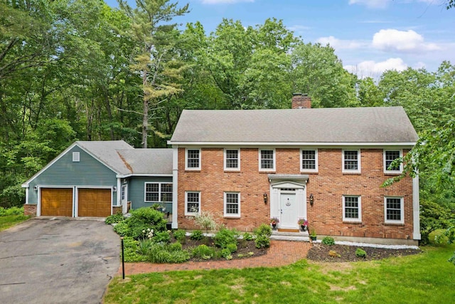 38 Piscataqua Rd, Dover, NH 03820 - view of front of house featuring a chimney, asphalt driveway, an attached garage, brick siding, and a front lawn