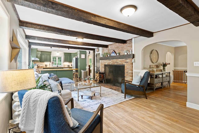 38 Piscataqua Rd, Dover, NH 03820 - living room with light wood-style flooring, a fireplace, beam ceiling, and arched walkways