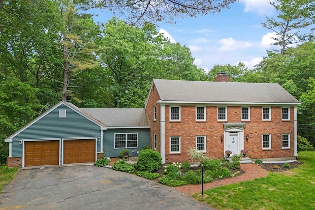 38 Piscataqua Rd, Dover, NH 03820 - colonial inspired home featuring an attached garage, asphalt driveway, a chimney, and brick siding