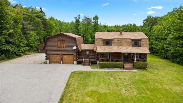 110 W Milan Rd, Milan, NH 03588 - log-style house with covered porch, log siding, a gambrel roof, a front lawn, and asphalt driveway