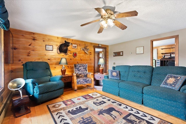 110 W Milan Rd, Milan, NH 03588 - living area with wood-type flooring, a ceiling fan, wooden walls, and a textured ceiling
