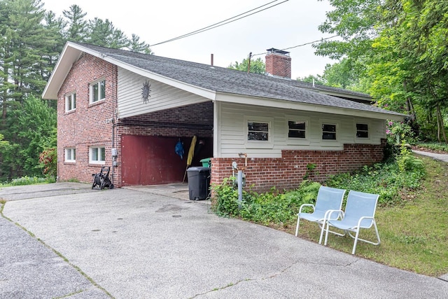 28 New Searles Rd, Nashua, NH 03062 - view of property exterior featuring brick siding, driveway, a chimney, roof with shingles, and an attached carport
