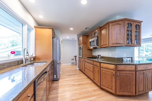 28 New Searles Rd, Nashua, NH 03062 - kitchen with appliances with stainless steel finishes, glass insert cabinets, dark stone countertops, recessed lighting, and light wood finished floors