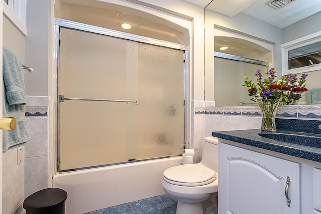 28 New Searles Rd, Nashua, NH 03062 - full bath featuring tile walls, tile patterned floors, vanity, shower / bath combination with glass door, and a wainscoted wall