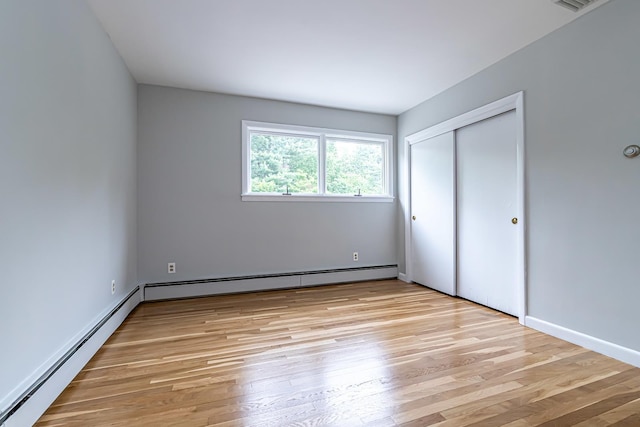 28 New Searles Rd, Nashua, NH 03062 - unfurnished bedroom featuring a baseboard radiator, light wood-style floors, and a closet