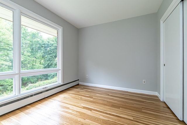 28 New Searles Rd, Nashua, NH 03062 - unfurnished bedroom featuring a baseboard radiator, light wood-type flooring, and multiple windows